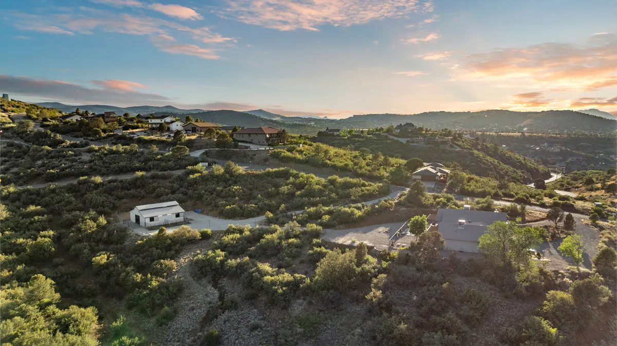 An expansive view of distant mountains, lush greenery, scattered houses, and winding roads—perfectly capturing the sense of wide-open space and natural beauty that surrounds the property. The scene is peaceful, inspiring exploration and outdoor adventure.