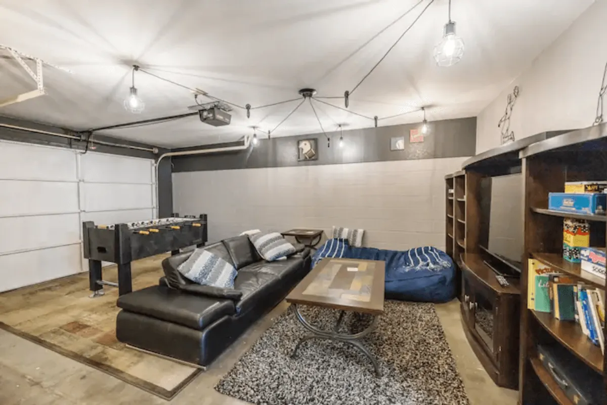 An inviting game room with a foosball table, plush bean bag chairs, a comfortable sofa, and a TV unit create a playful and relaxed environment. The layout suggests a space ideal for friendly competitions, gatherings, and movie marathons, aligning perfectly with the 'Entertainment for All Ages' theme.