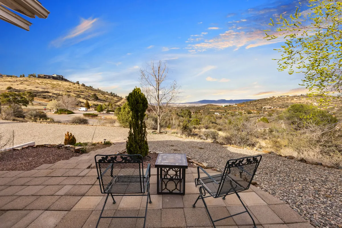 This image shows an outdoor seating area with comfortable chairs, manicured landscape shrubs, and a wide view of the mountains. The scene offers a serene spot for morning coffee, reading, or casual group gatherings, reinforcing the connection to natural beauty and the retreat’s relaxing environment.